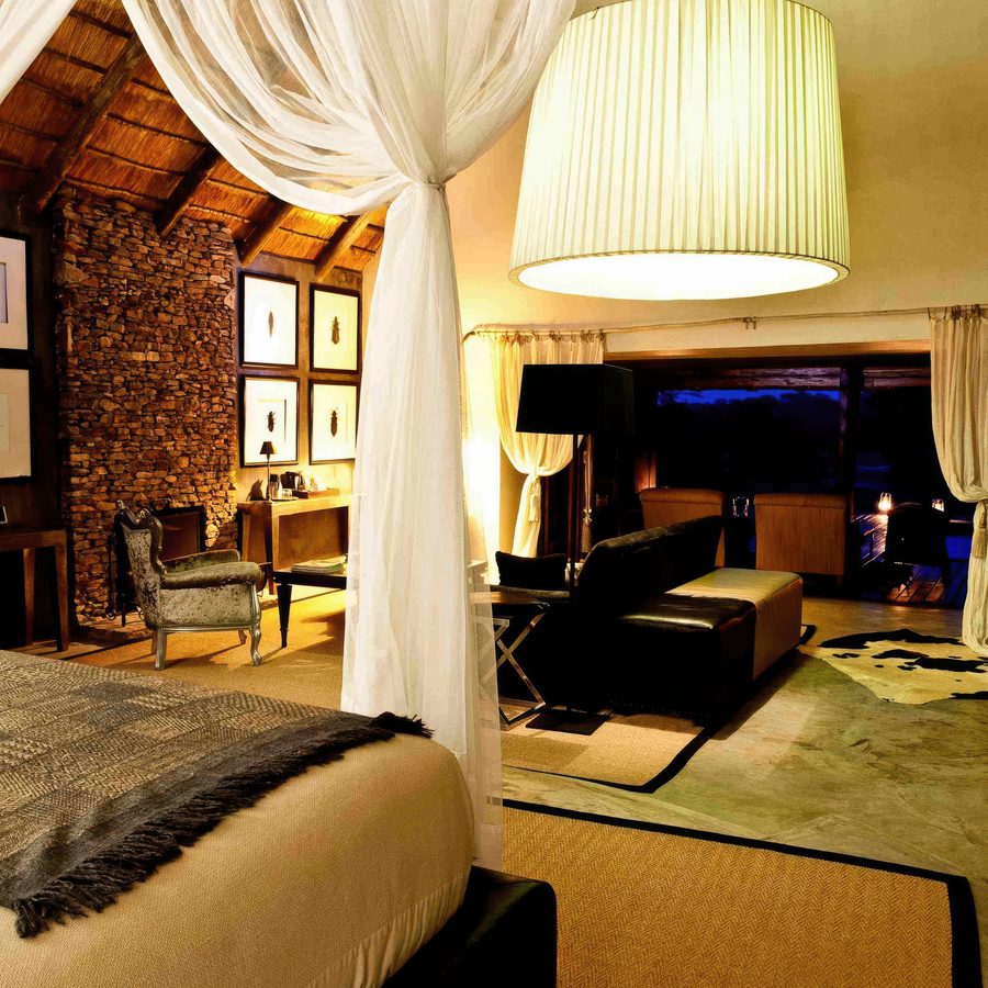 Pleated pendant shade above the bed in a game lodge suite
