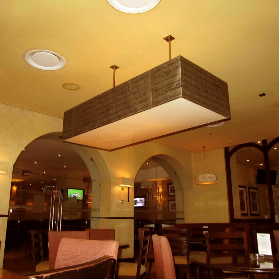 Large rectangular pendant shade over a restaurant seating area